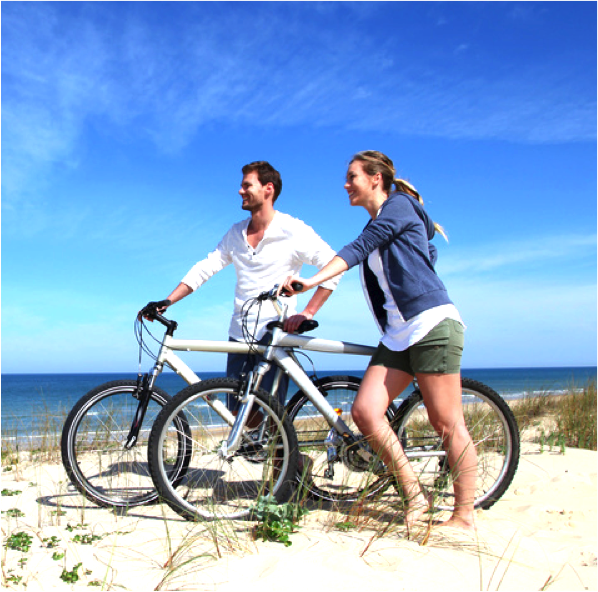 Paar fährt Fahrrad am Strand